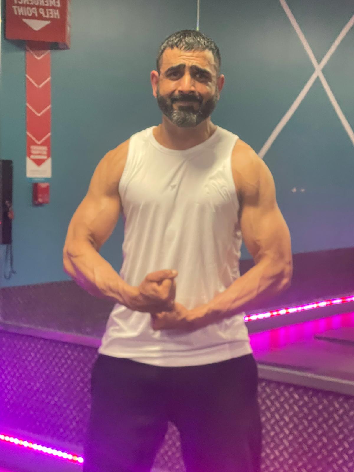Naveed posing in the gym