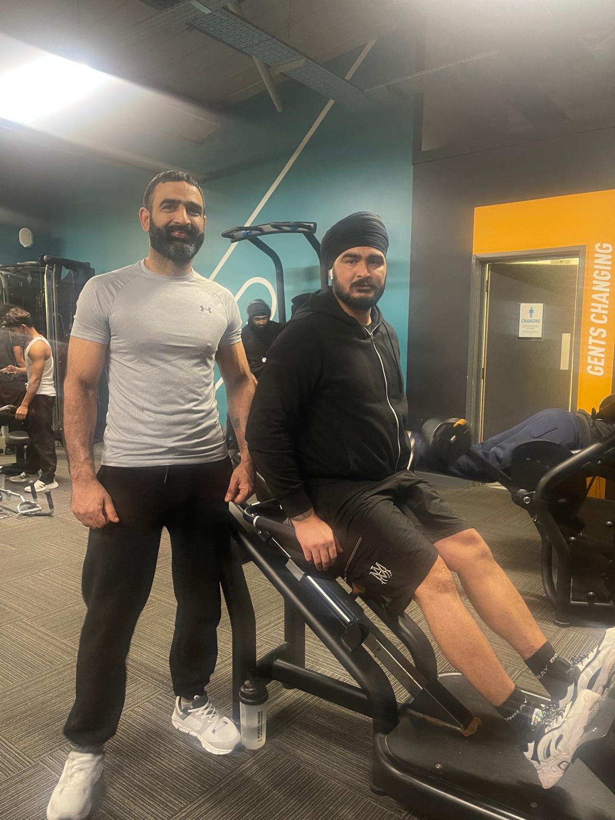 Trainer and client by gym equipment